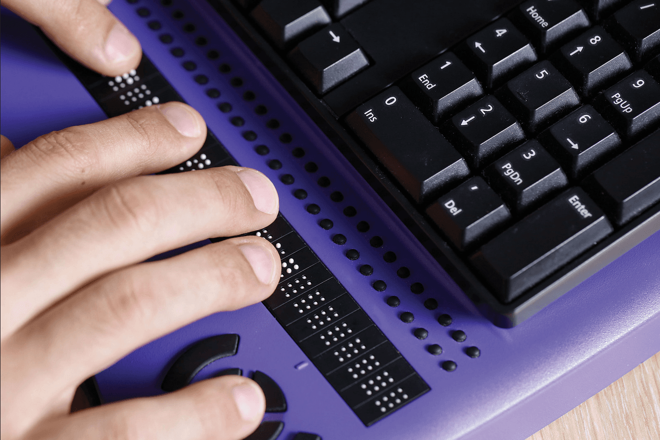 Person using a braille keyboard and assistive technology device